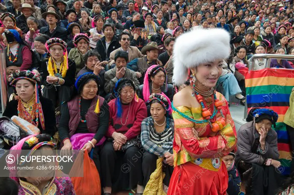 Singer wearing Ethnic Tibetan costume and jewelry waits to perform at folk festival, Danba, Sichuan Province, China
