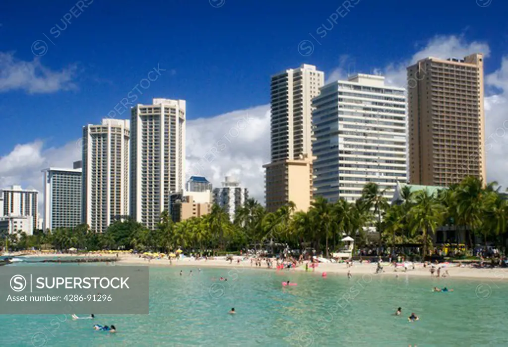 The Waikiki Beach in Oahu, Hawaii has white sand, palm trees, swimming, surfing and sunbathing. It is definately the place to see and be seen.