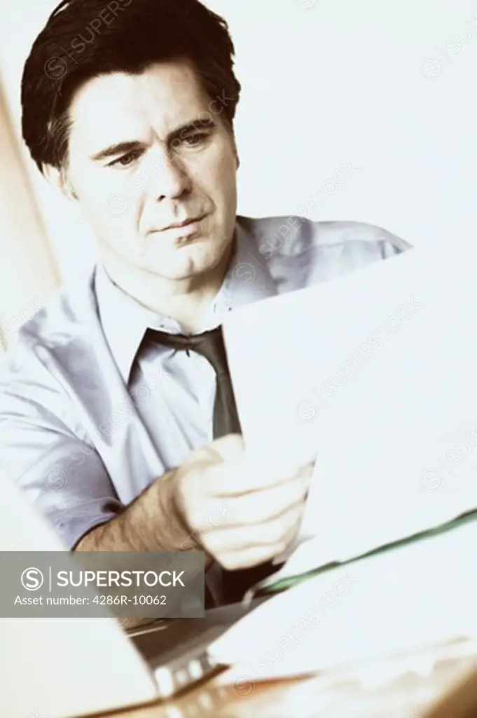 Late 40s Caucasian male businessman with stack of paperwork  MR-0415