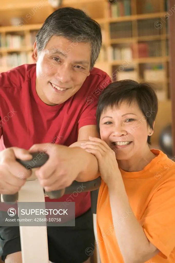 Senior Asian Couple on exercise stepper machine.  PR