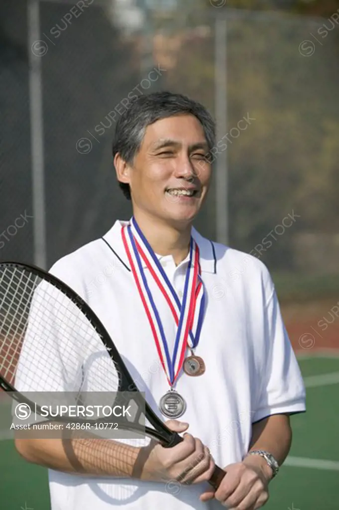 Senior Asian man and tennis games medals.