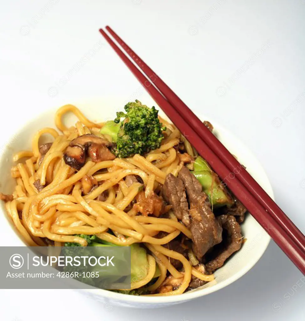 A bowl of beef chow mein with chopsticks