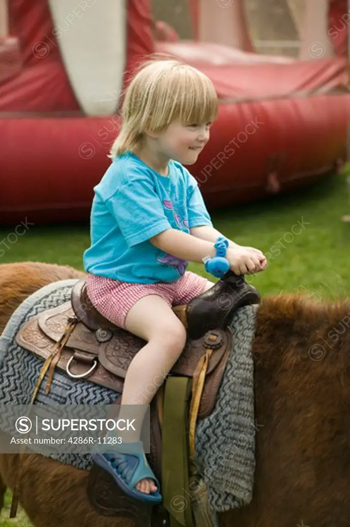 Young girl (3 yrs) on pony ride.MR-0501