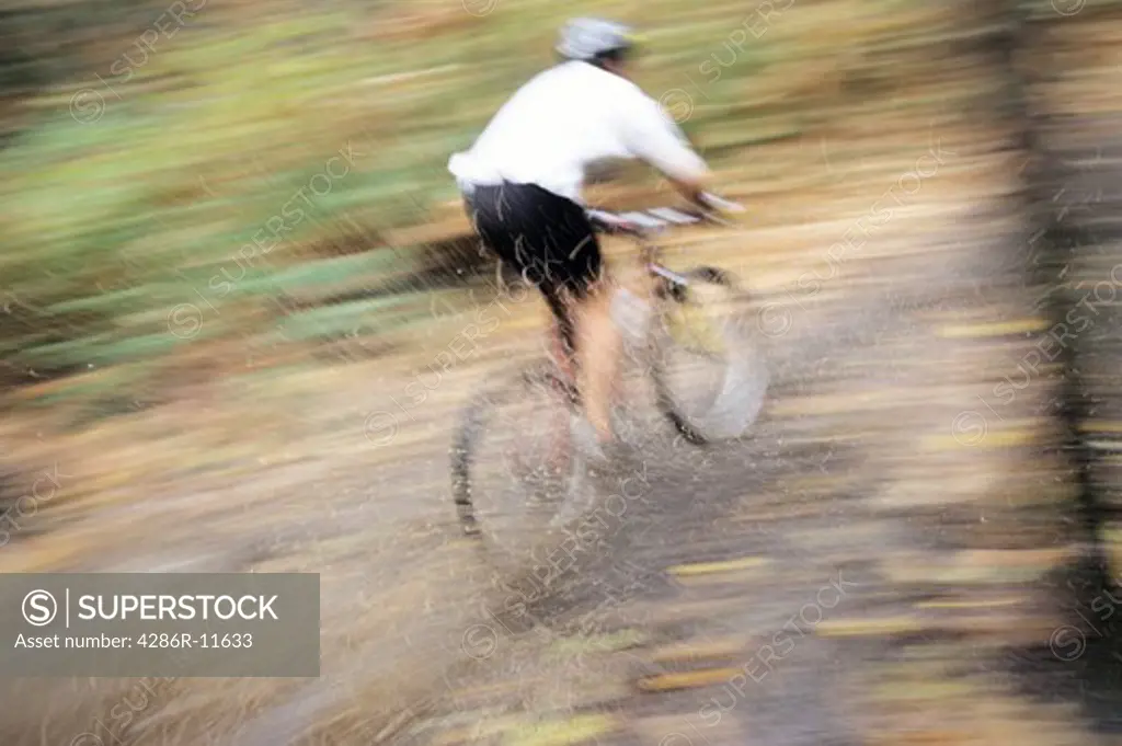 Mountain biker going through a mud puddle.