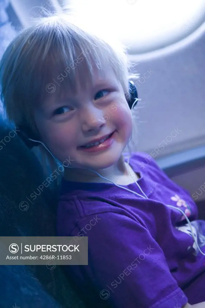 4 year old girl in plane with headphones..  MR-0501