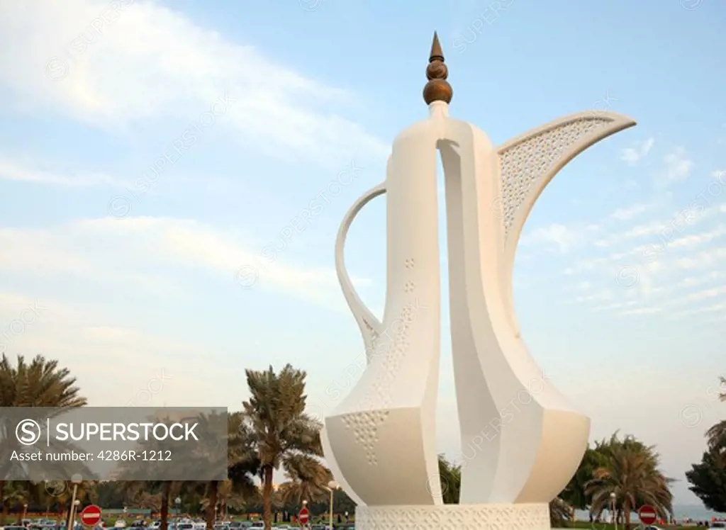 The 'Dallah' coffee-pot monument on the Corniche in Doha, Qatar. The Doha Sheraton Hotel is visible behind palms bottom left A dallah is a symbol of welcome and hospitality in Arabia.