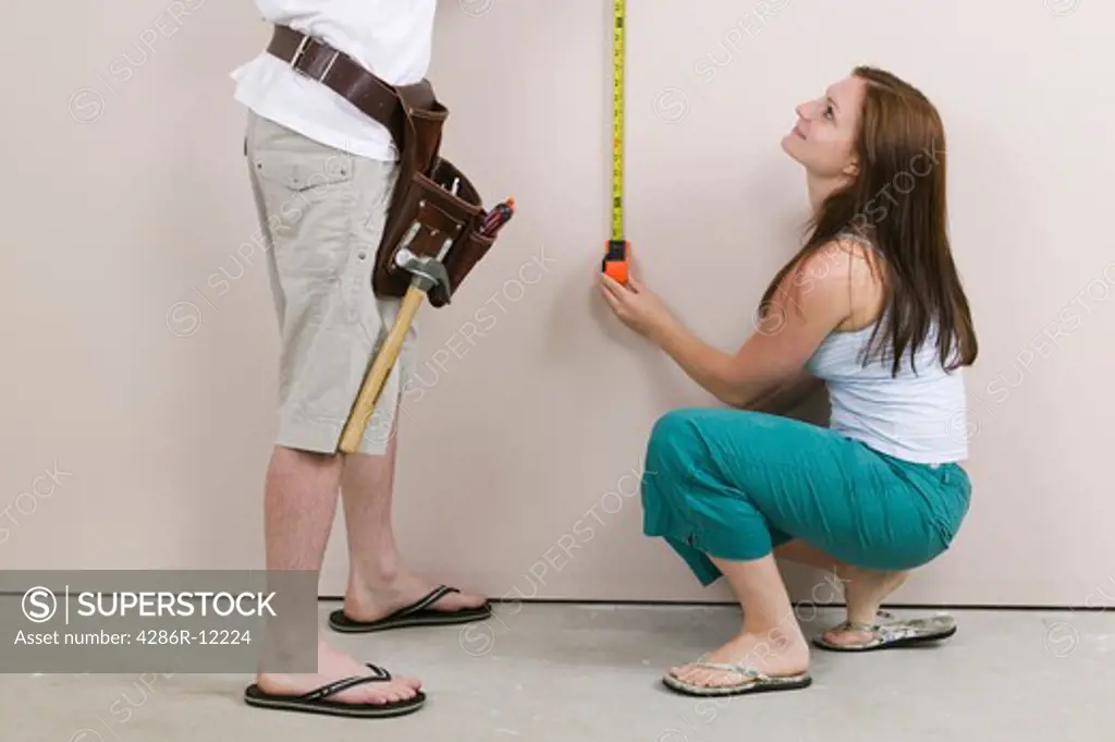 Couple Measuring a Wall