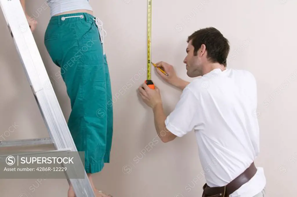 Couple Measuring a Wall