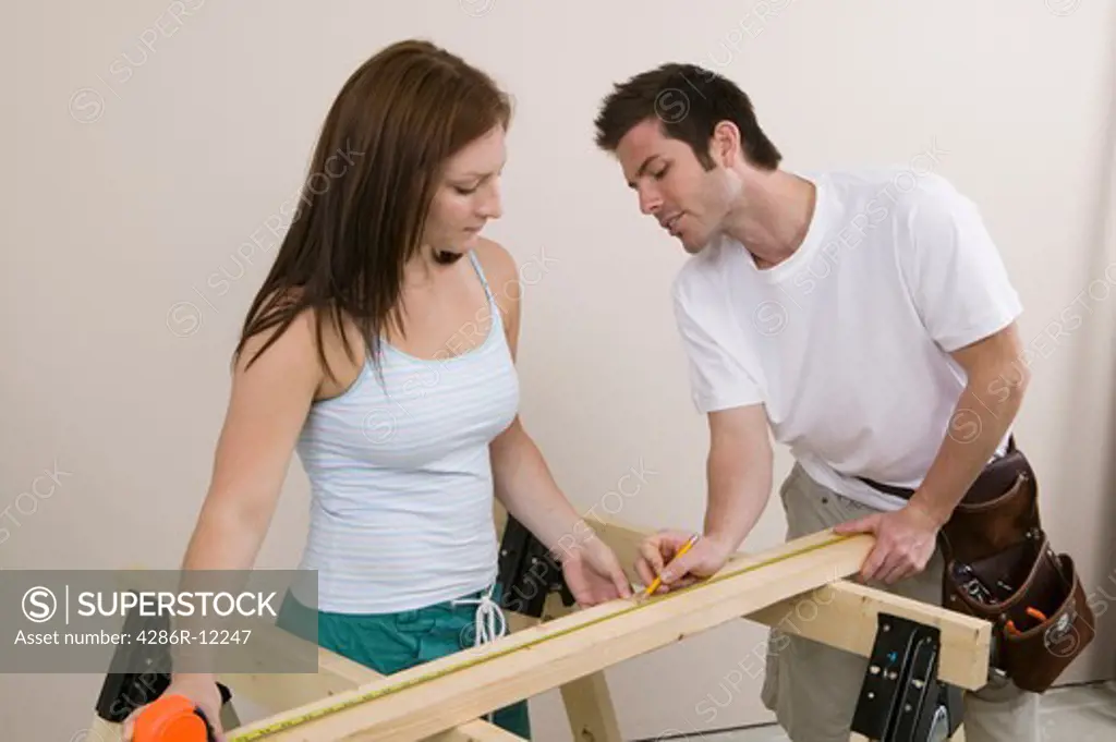 Couple Measuring a Board