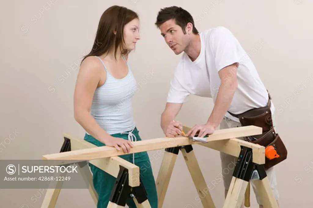Couple Measuring a Board
