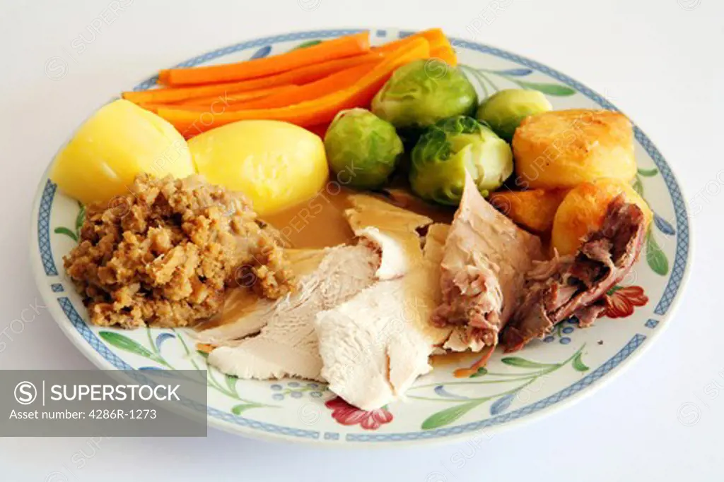 A plate of festive favourites: turkey, roast potato, brussels sprouts, boiled potato, gravy and stuffing.