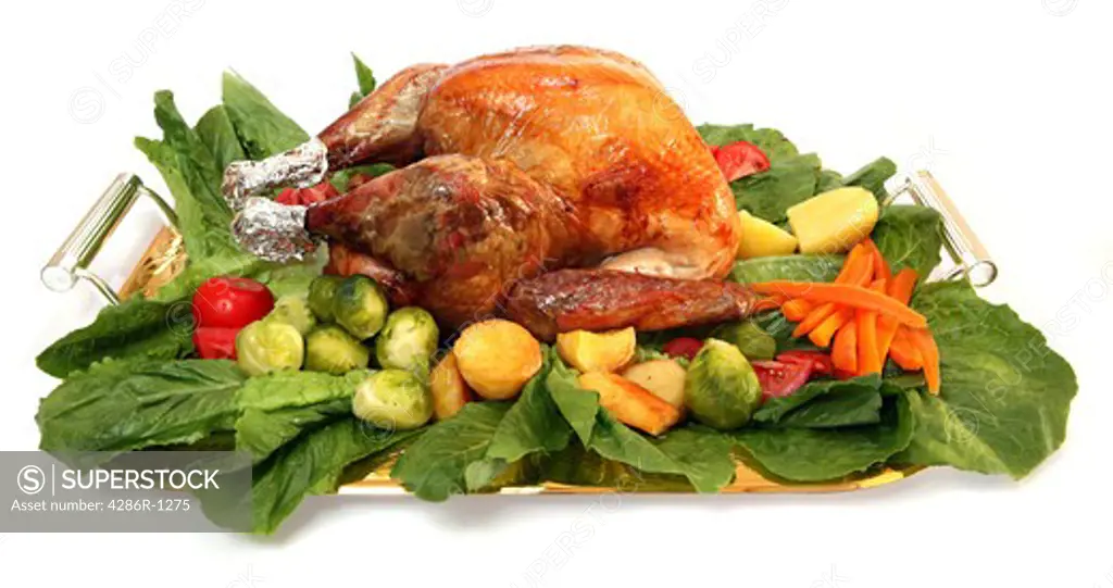 A festive platter, loaded with a roasted turkey and an assortment of delicious vegetables.