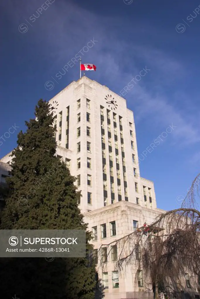 Vancouver City Hall with Canada Flag standing proud on blue sky - Vancouver BC