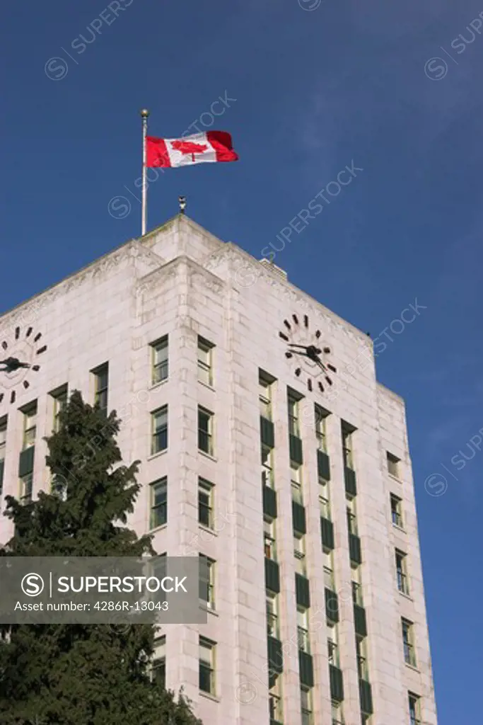 Closeup of Vancouver City Hall with Canada Flag on blue sky - Vancouver BC