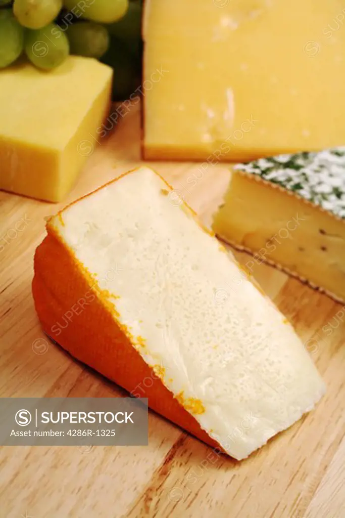 Port Salut cheese on a board with a variety of other gourmet cheeses