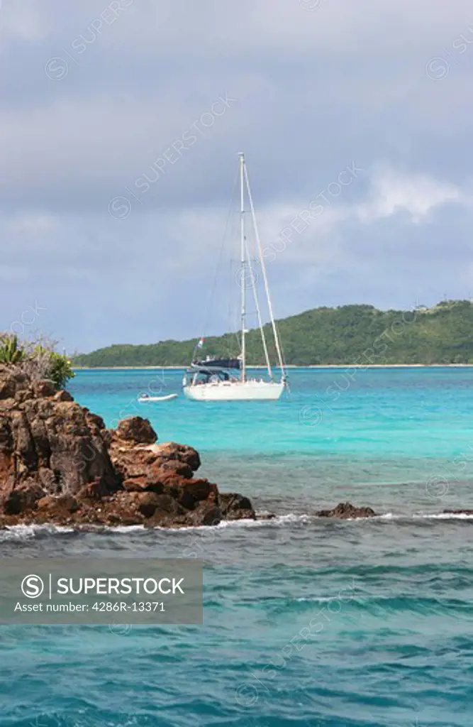 Small Sailboat anchored off small Caribbean Island in the Tobago Cays - St Vincent