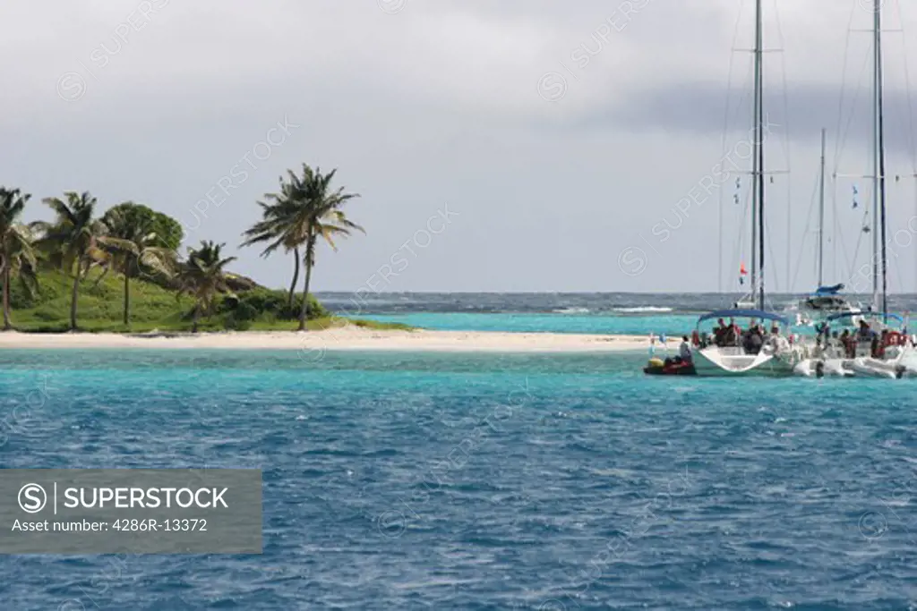 Pleasure boats anchored off deserted island in the Tobago Cays - Saint Vincent