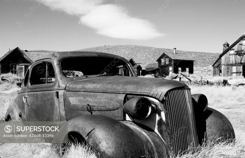 Abandoned, rusted out coupe in ghost town of Bodie, California - Black and White
