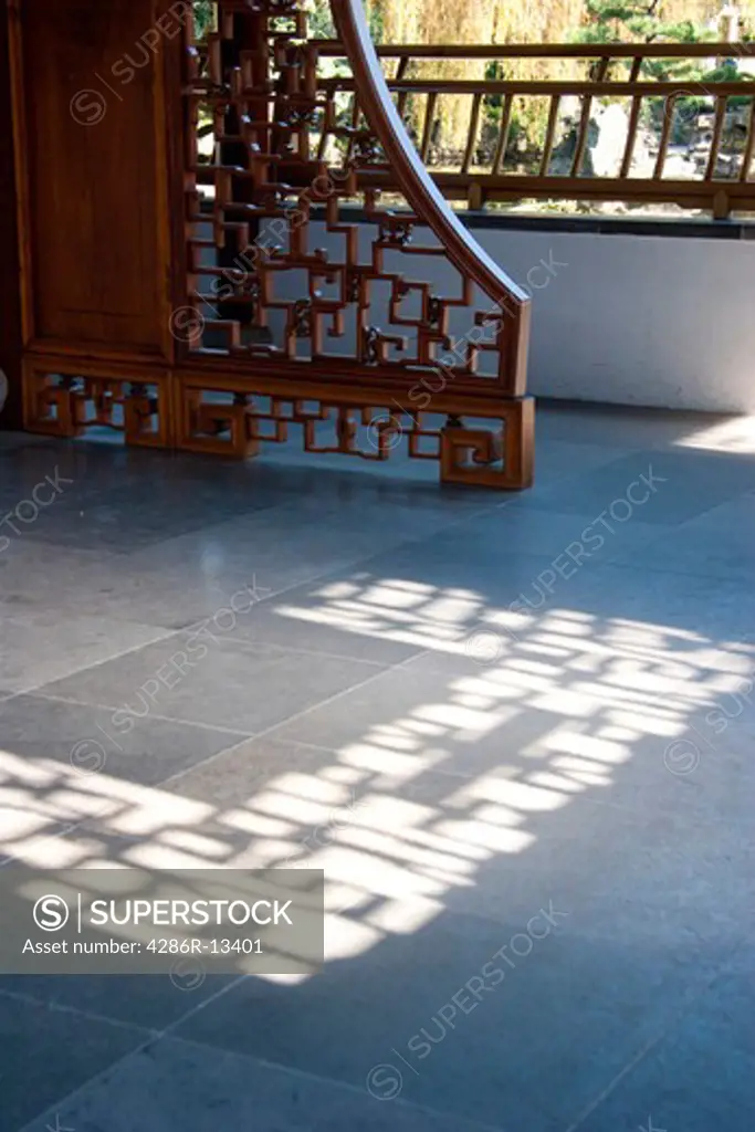 Ornate wooden screen casts interesting shadow on stone floor. Dr. Sun Yat-Sen Gardens, Vancouver Chinatown