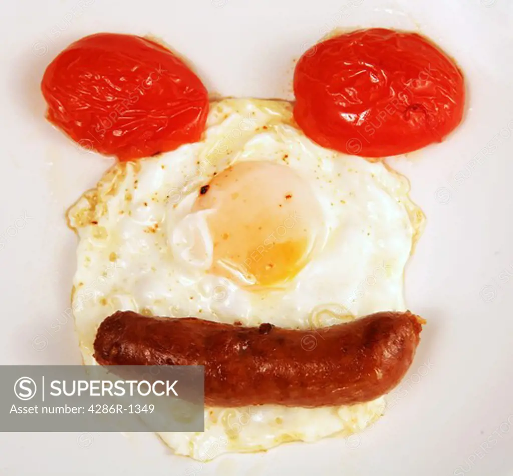 A smiley face of tomato, egg and sausage