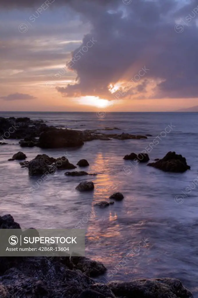 Setting sun reflected in the calm Pacific Ocean, Maui