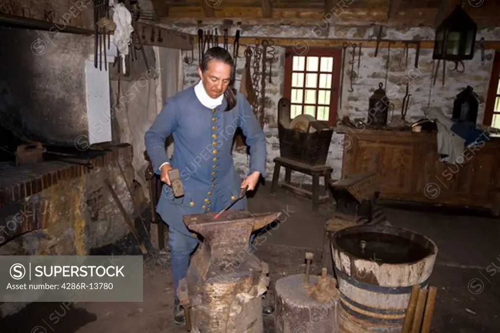 Period actor forging a iron tool at Fortress of Louisbourg National Historic Site, Cape Breton, Nova Scotia, Canada