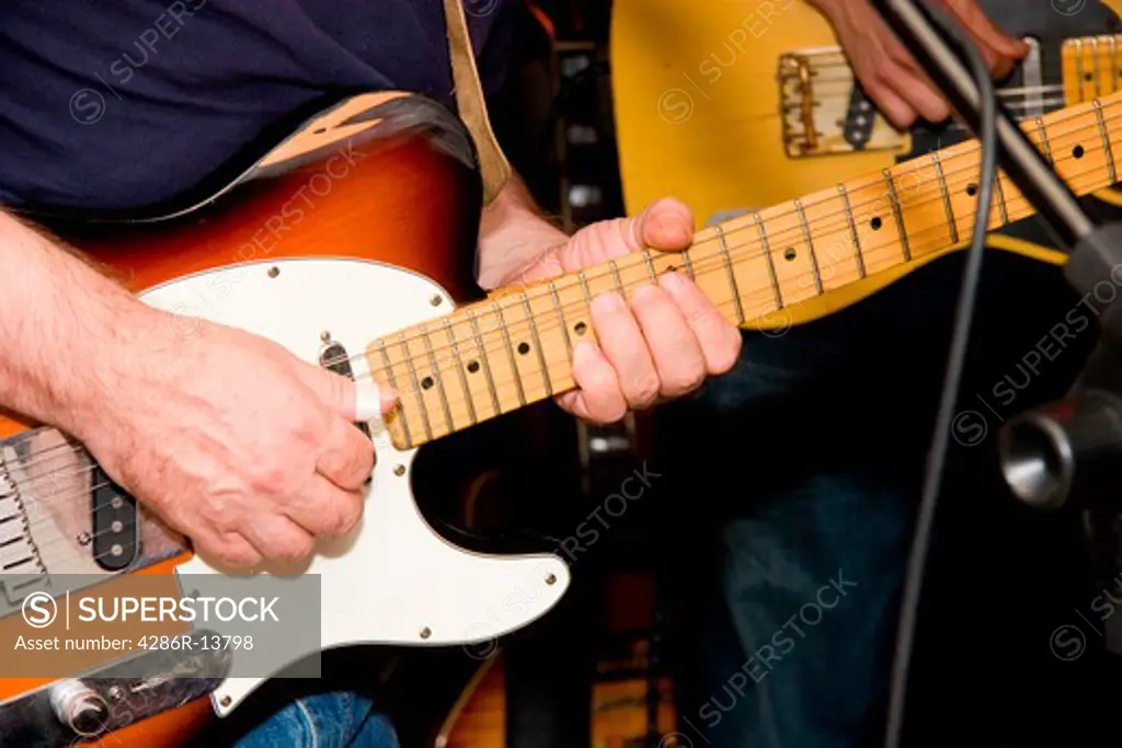 Two guitar players on stage in a bar band
