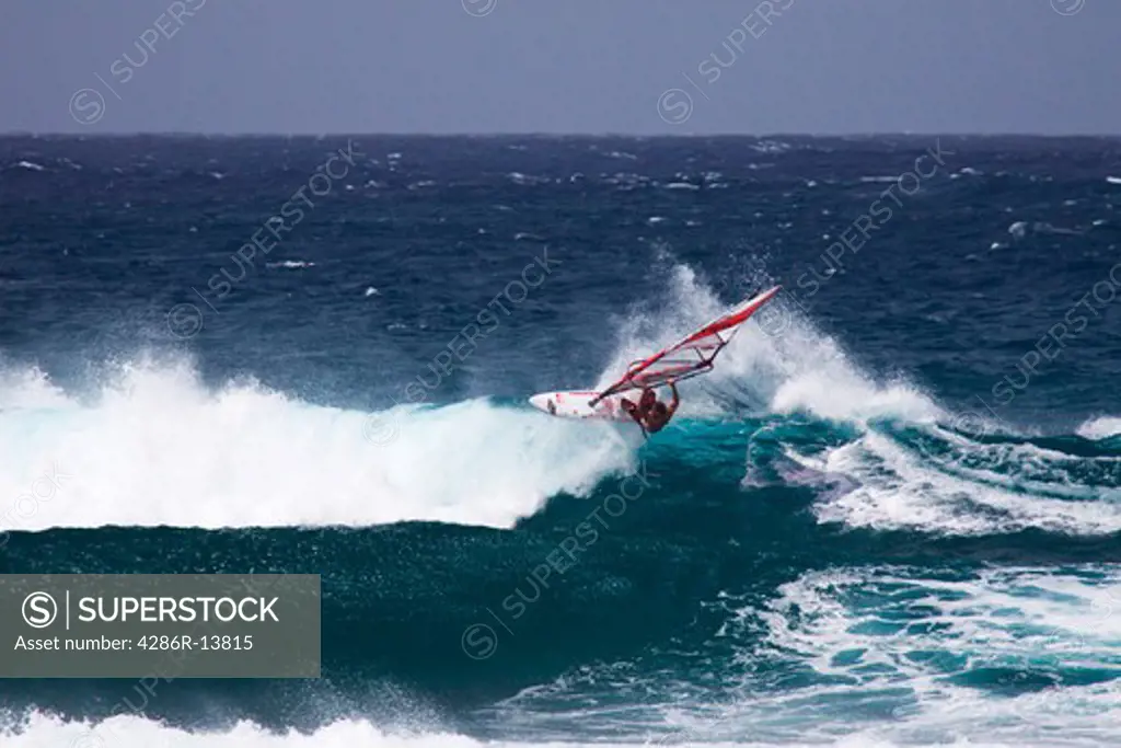 Riding the edge. Windsurfing on Mauis famous Hookipa Beach, located on the windy North Shore.