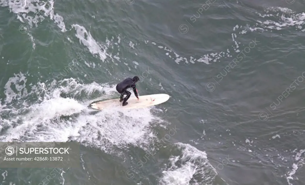 Aaerial View of surfer in wet suit riding a wave. San Francisco Bay, California, USA