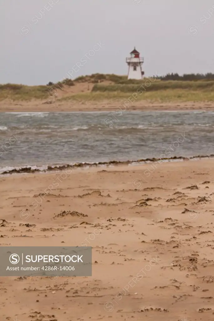 Blowing sand with Lighthouse in background, Prince Edward Island National Park, on the north shore of Prince Edward Island, Canada