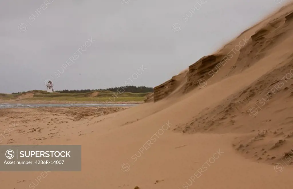 Shifting sand dunes with Lighthouse in background, Prince Edward Island National Park, on the north shore of Prince Edward Island, Canada