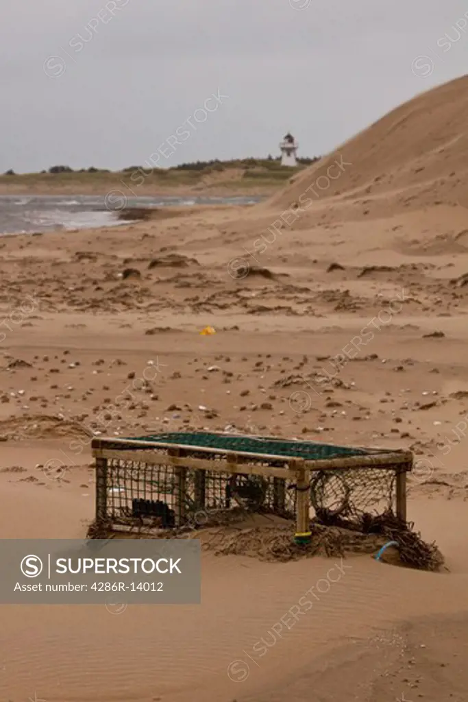 Lobster trap stuck in the shifting blowing sand, Prince Edward Island National Park, on the north shore of Prince Edward Island, Canada