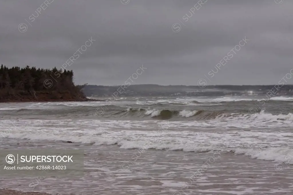 The town of North Rustic Harbour as seen beyond storm swept seas on the north shore of Prince Edward Island, Canada