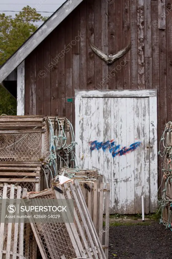Lobster traps in front of shed with tuna tail over door, North Rustico Harbour on the north shore of Prince Edward Island, Canada