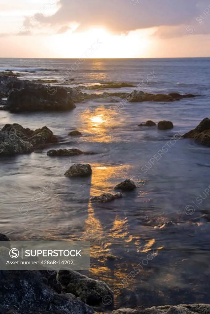 Maui sunset reflected in the calm rocky ocean