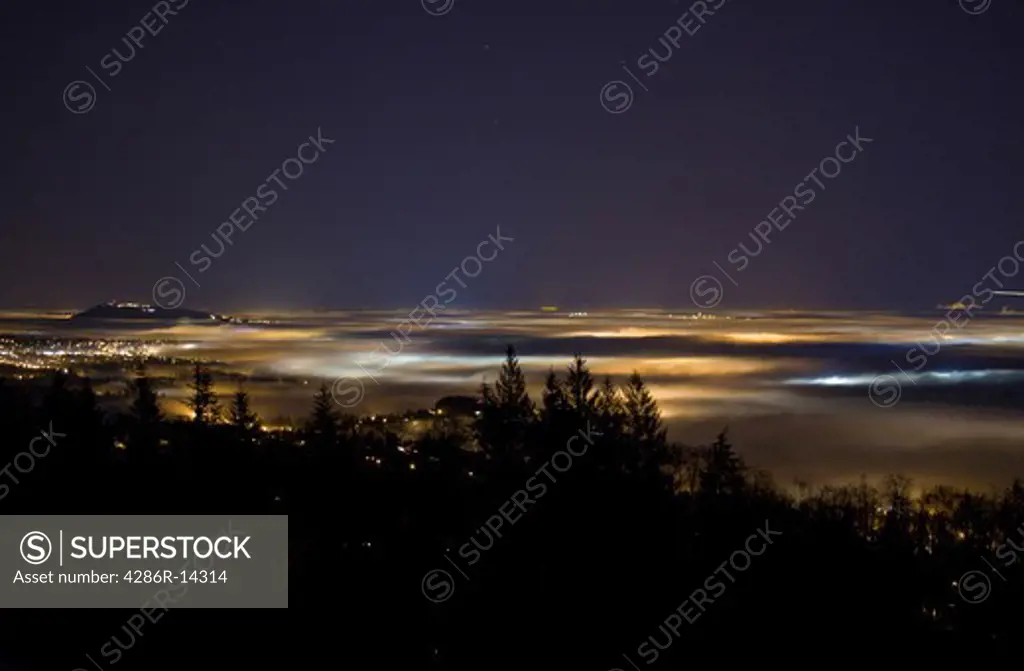 Vancouver and the Fraser Valley shrouded in fog - Lights of the city cast colorful glows at night