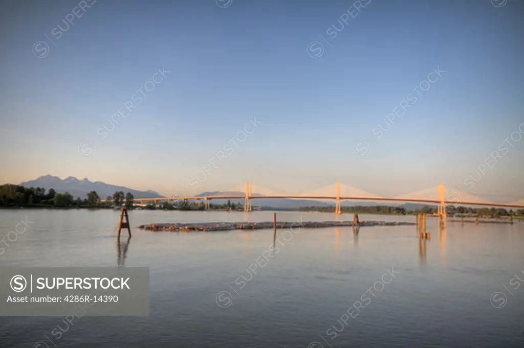 New Golden Ears Bridge 2009 over the Fraser River between Maple Ridge and Langley, BC. Golden Ears Peaks on left side, log boom in foreground.