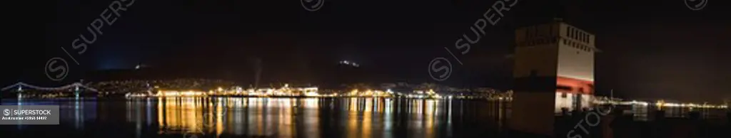 Vancouver night panoramic of Lions Gate Bridge, north shore mountains and Stanley Park seawall