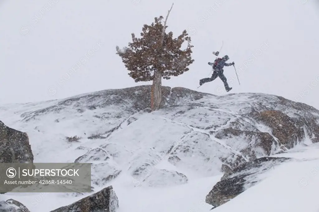 A snowboarder hiking in a storm in the Sierra Mountains of CA.