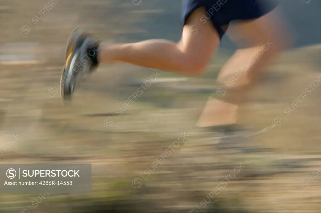 A blurry shot of the feet and legs of a runner.