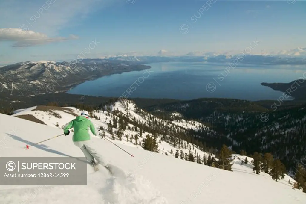 A woman skiing above Lake Tahoe, CA at sunset.