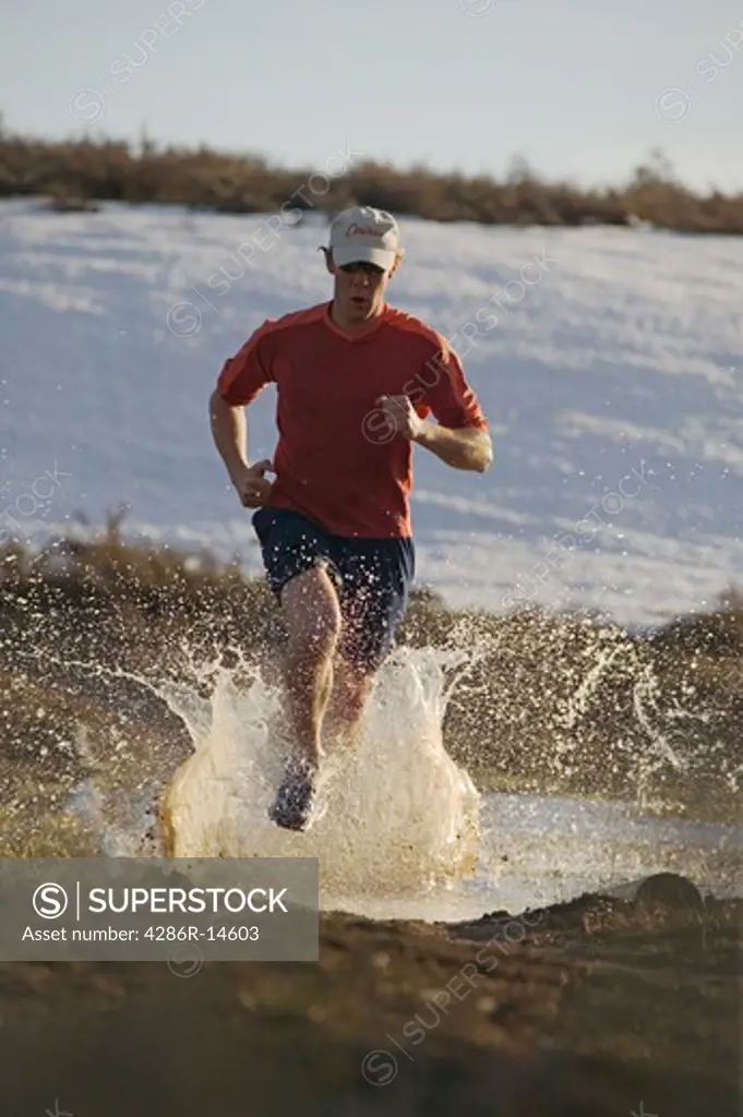 A man running on a trail covered with water near Truckee, CA.
