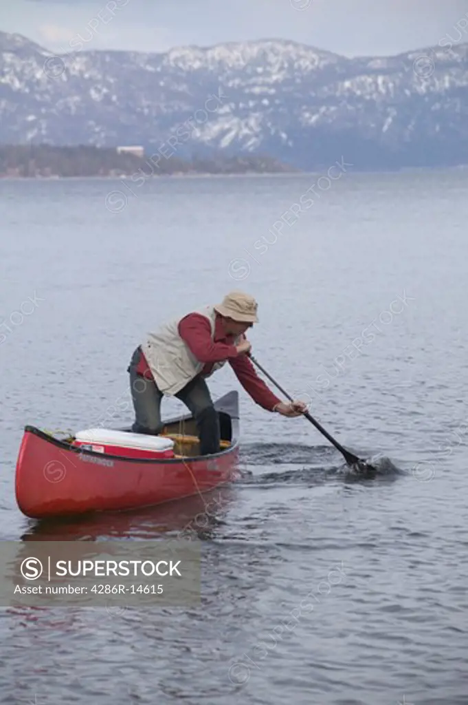 A fisherman canoeing on Lake Tahoe, CA.