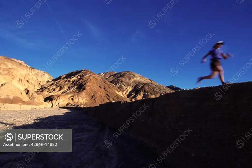 A woman running along a desert trail near Death Valley, CA.