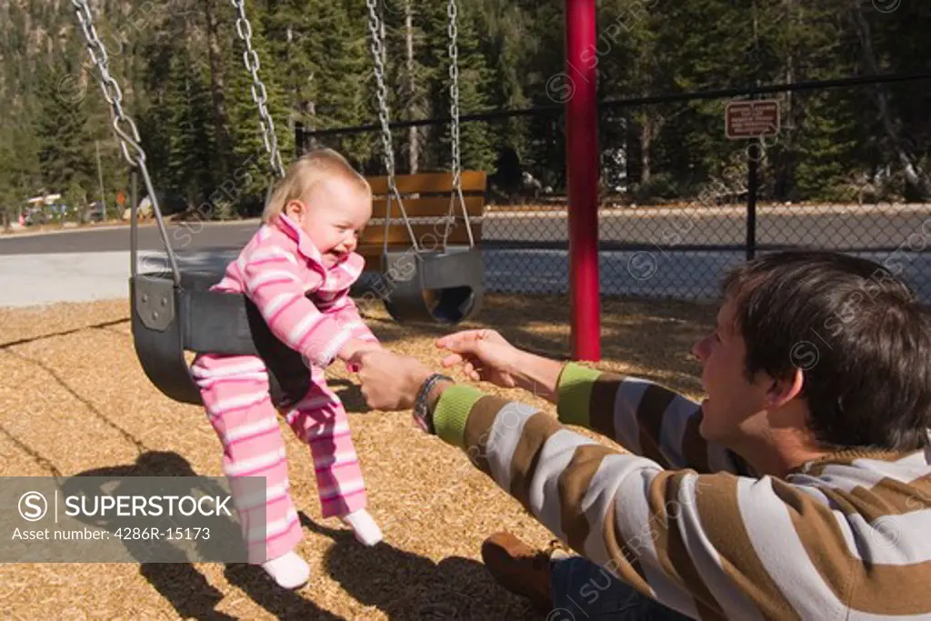 A father and child swinging in a playground near Squaw Valley California