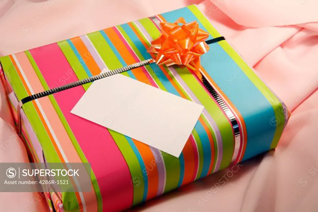 A present on pink cloth with a blank,textured tag