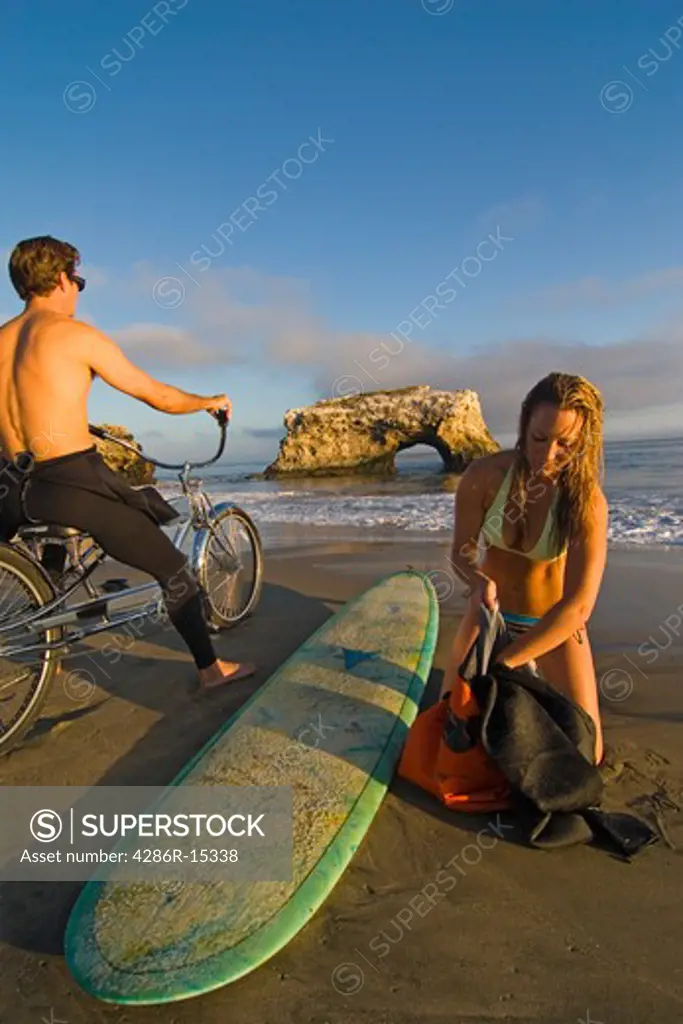 A Couple on the beach after a day of surfing at Natural Bridges State Park near Santa Cruz California