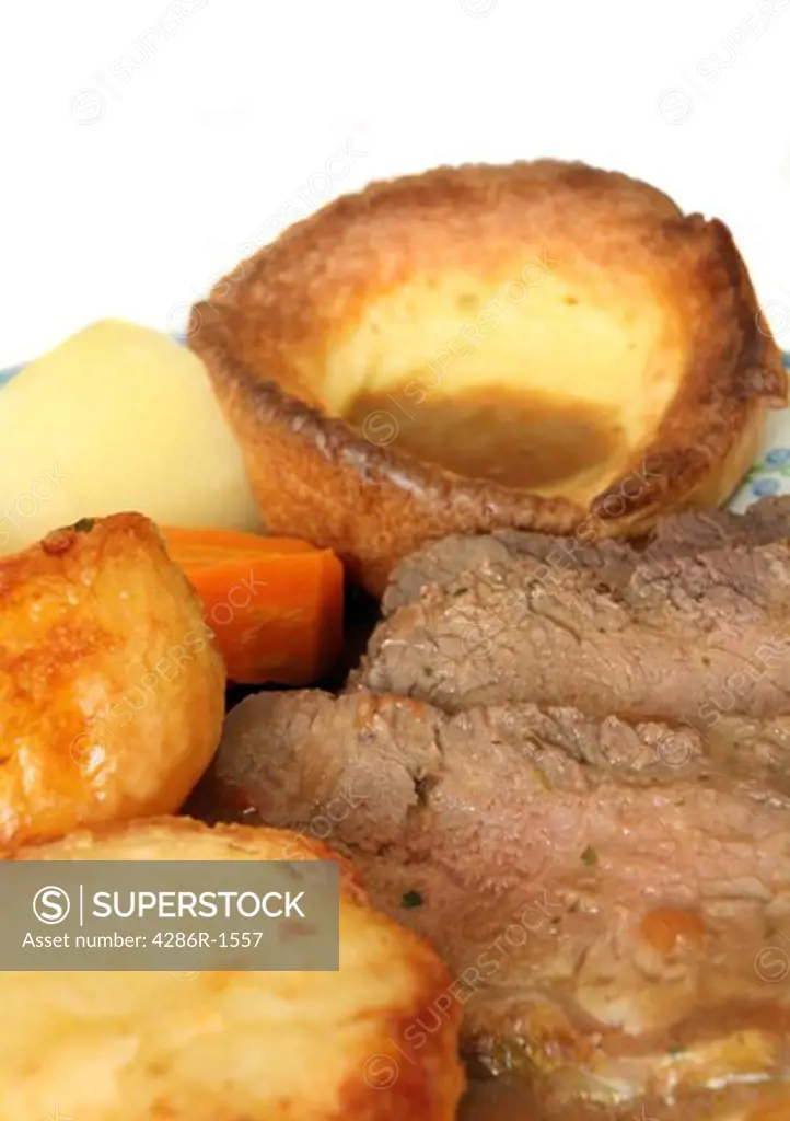 Roast beef and Yorkshire pudding, roast and boiled potatoes, boiled carrots and gravy. A traditional British Sunday dinner
