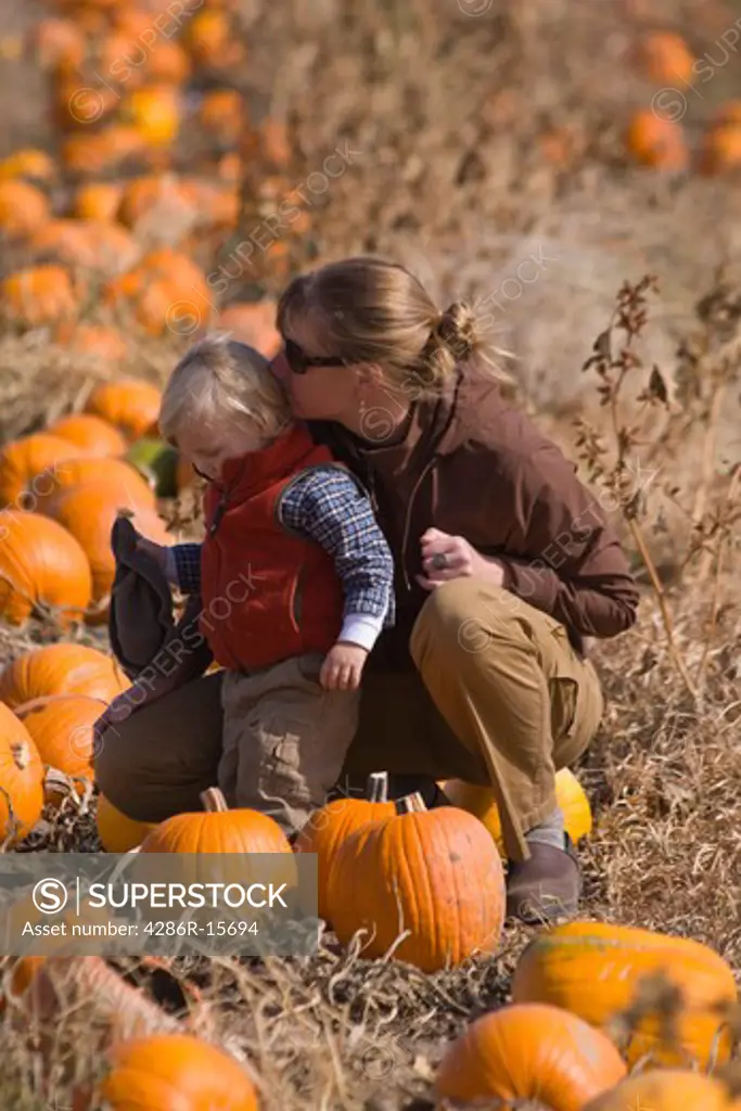A mother kissing her son in a pumpkin patch in Fallon Nevada