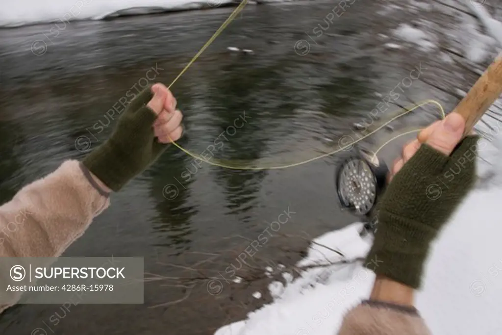A man fly fishing on a snowy day on the Truckee river near Truckee in California